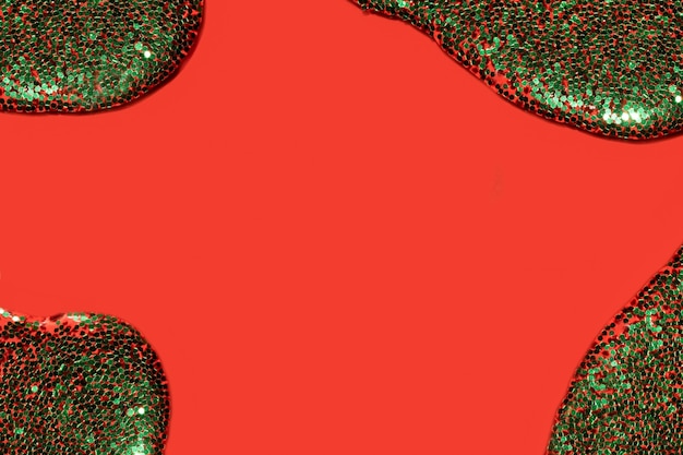 Transparent liquid with green glitter pouring over a coral red background festive backdrop for your project