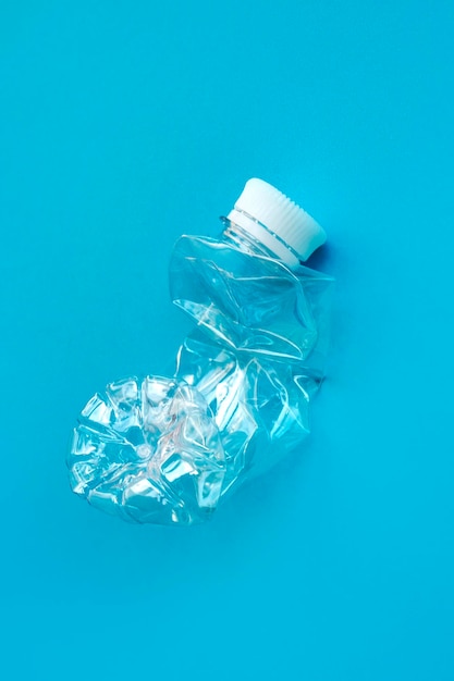 Transparent plastic bottle on a solid blue background for recycle waste Waste separation conceptProtect the environment Garbage processing Preserve nature Selective focus