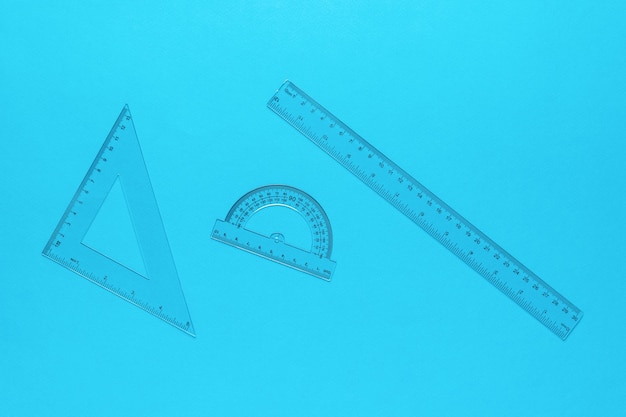 Transparent ruler triangle protractor on a blue background