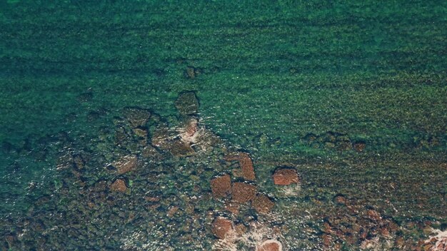 Transparent sea water splashing over coastal stones top view waves on stone