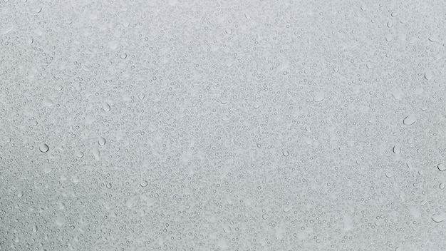 Transparent water droplets on a glass background