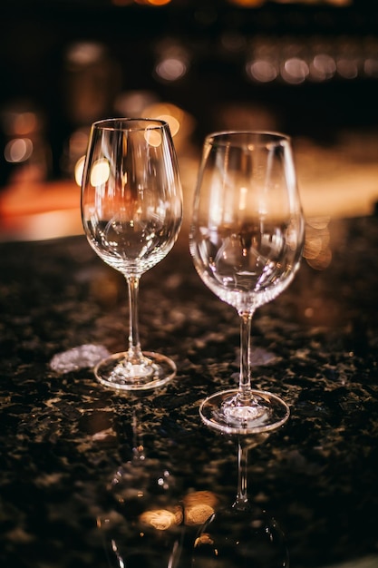 Transparent wine glasses with bokeh of bright lights. Glasses on a light background