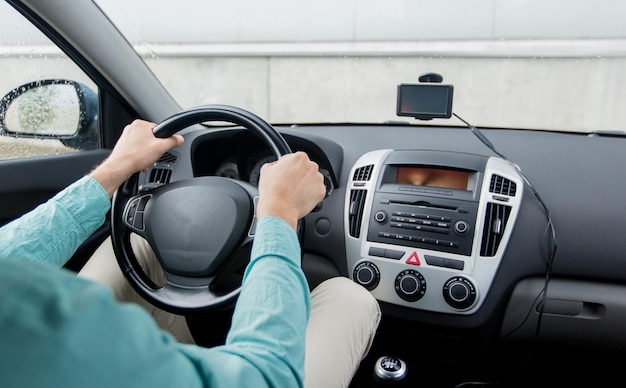 transport, business trip, destination and people concept - close up of young man driving on car parking