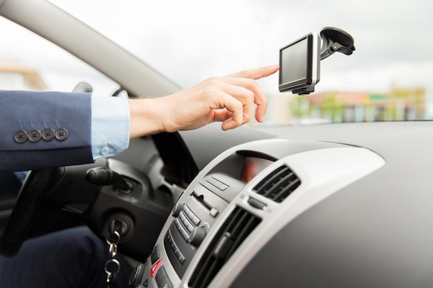 transport, business trip, technology, navigation and people concept - close up of male hand using gps navigator while driving driving car