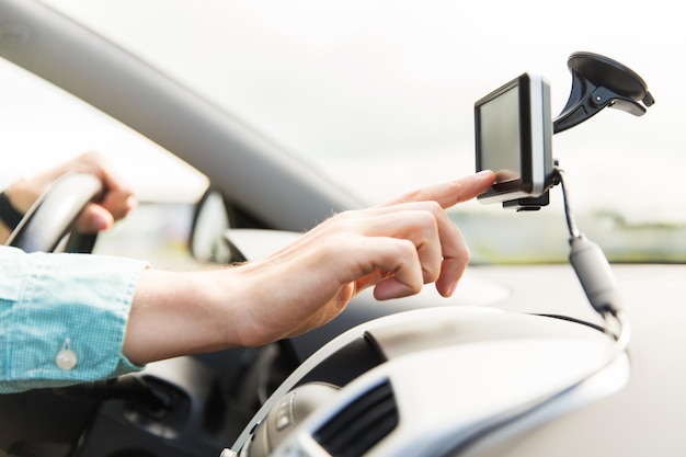 transport, business trip, technology, navigation and people concept - close up of male hand using gps navigator while driving driving car