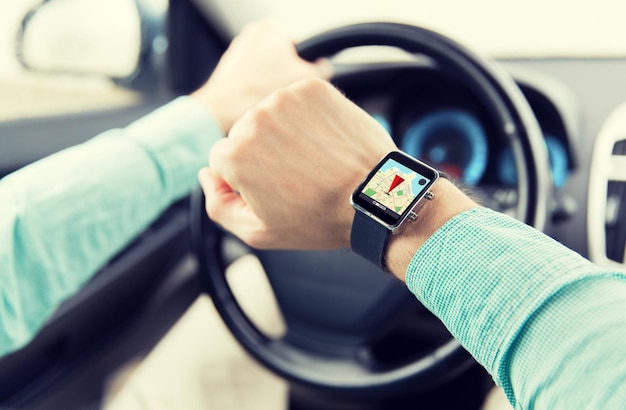 transport, business trip, technology, navigation and people concept - close up of man with smartwatch driving car and using gps navigator