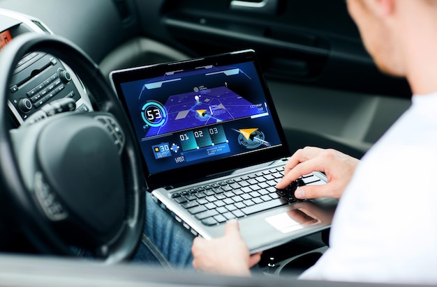 transport, modern technology and people concept - man using navigation system on laptop computer in car