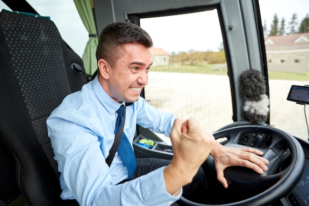 transport, tourism, gesture, emotion and people concept - angry driver showing fist and driving bus