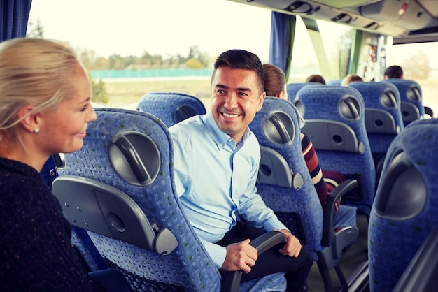 transport, tourism, road trip and people concept - group of happy passengers or tourists in travel bus