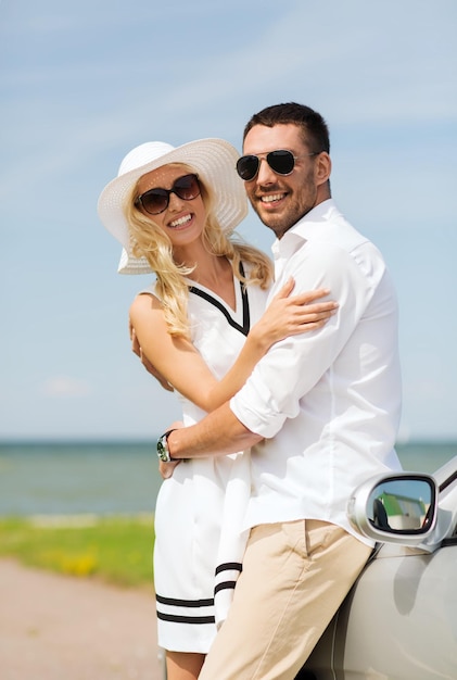 transport, travel, love, date and people concept - happy man and woman hugging near cabriolet car at sea side