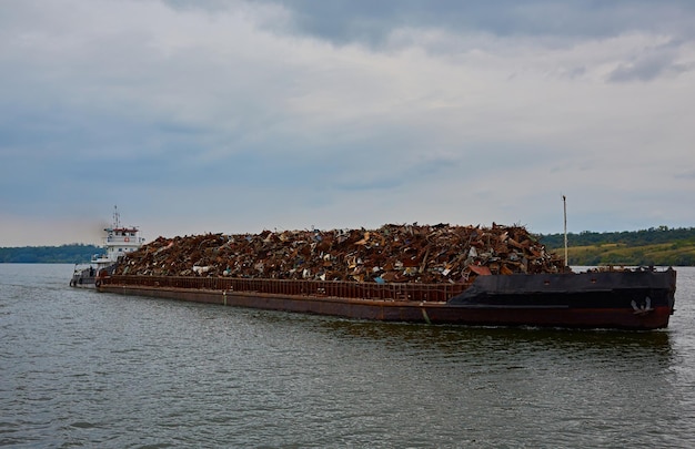 Transportation industry Ship barge transports scrap metal and sand with gravel