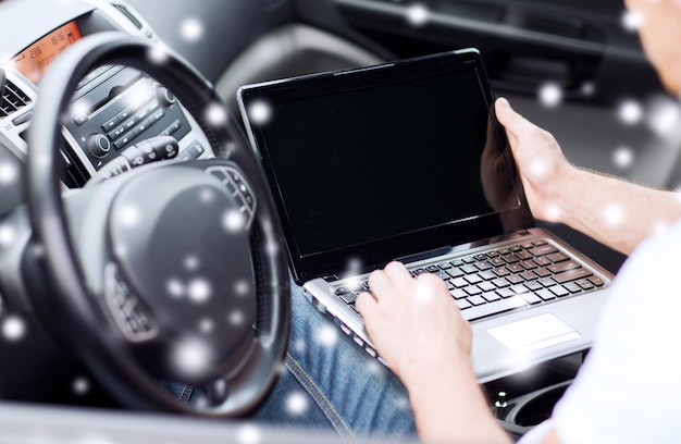 transportation, people, technology and vehicle concept - close up of man using laptop computer in car