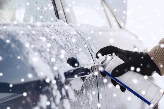 transportation, winter, people and vehicle concept - closeup of man hand with lock door de-icer