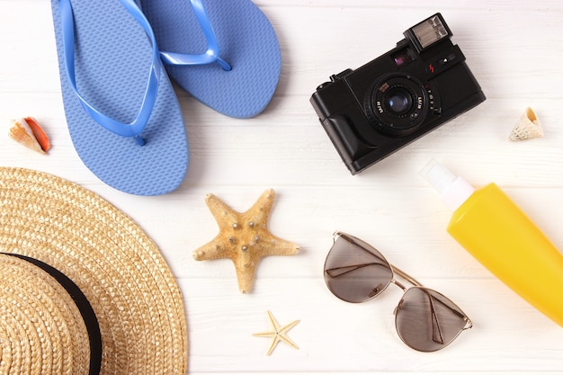 Travel accessories and tropical leaves on a colored background top view