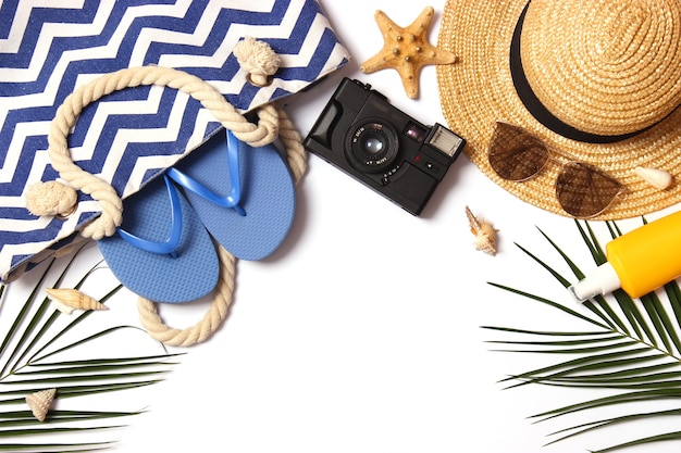 Travel accessories and tropical leaves on a colored background top view