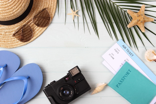 Travel accessories and tropical leaves on a colored background top view