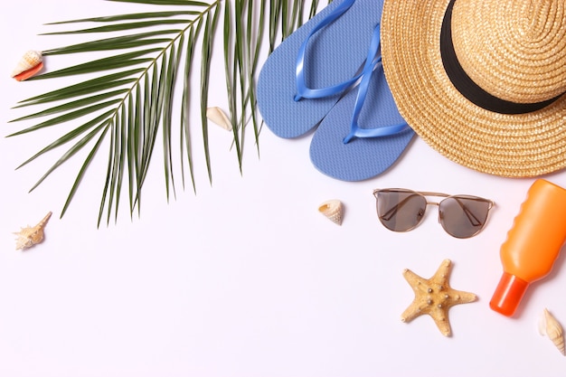 Travel accessories and tropical leaves on a colored background top view