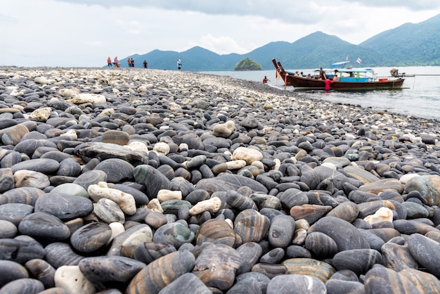 Travel Andaman Sea to Ko Hin Ngam island and the arrival of tourists by long tail boat and beautiful nature of the rock with strange black color at Tarutao National Park, Satun, Thailand