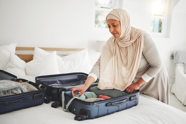 Travel bedroom and Muslim woman with suitcase packing for holiday vacation and religious trip Home luggage and Islamic female person with clothes in bag prepare for journey adventure and tourism