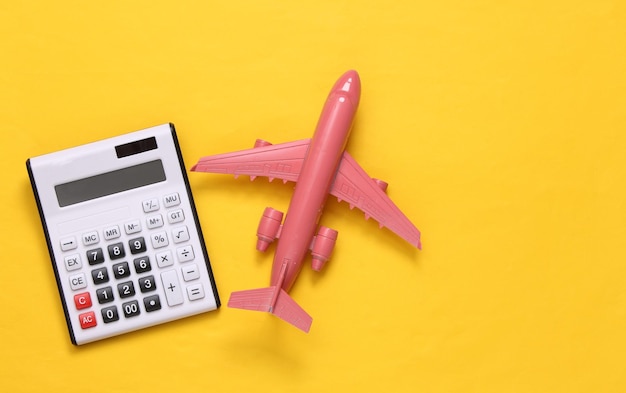 Travel concept Calculator plane on yellow background Top view Flat lay