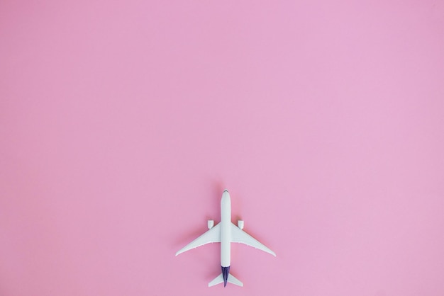 Travel concept on pink background with copy space Airplane toy on pink color background