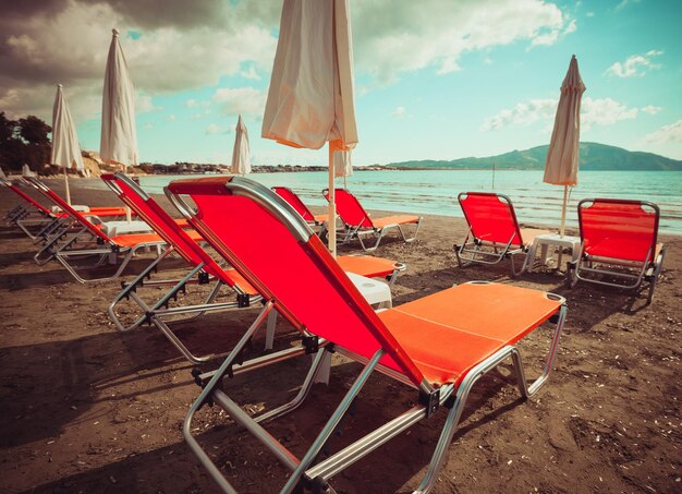 Travel concept - sunchairs with  umbrellas on beautiful  beach, Zakynthos  island, Greece