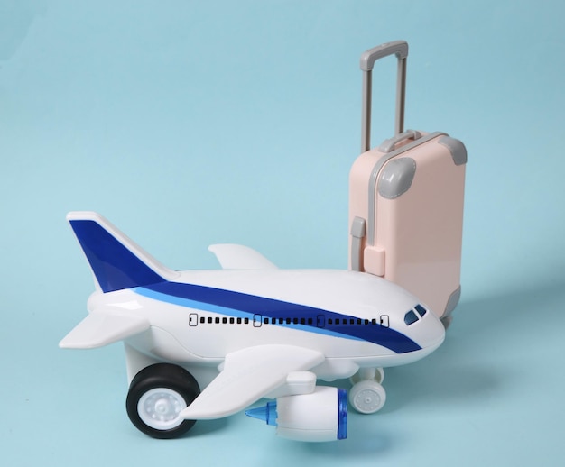 Travel concept Toy passenger plane and luggage on a blue pastel background