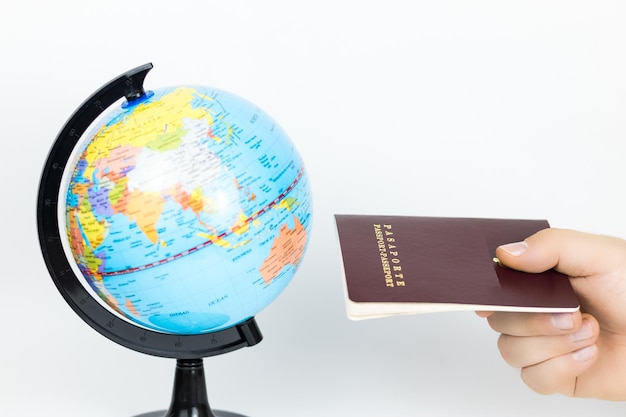 Travel concept with world map and passport in hand with copy space