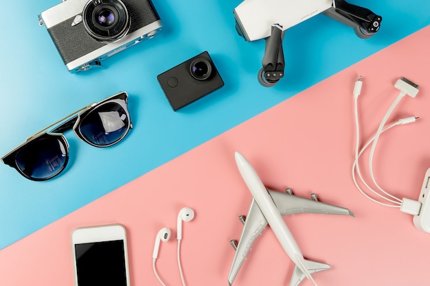 Travel Gadgets on blue and pink pastel background