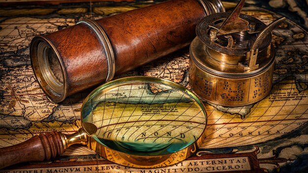 Travel geography navigation concept old vintage compass with sundial spyglass rope on world map