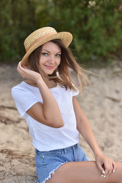 Travel girl or woman walk on beach with sand and takes pictures wind blows the blonde hair on shore