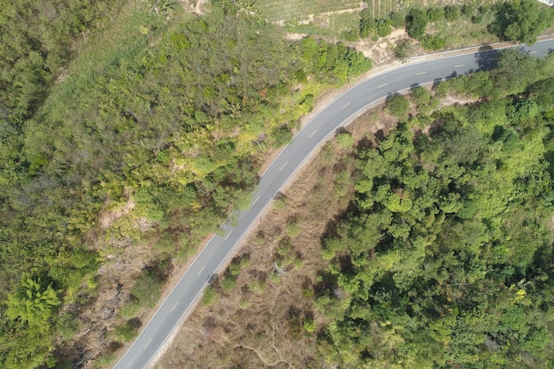 Travel on hilly road in spring aerial view road curve construction up to mountain Amazing top down image from drone camera