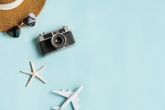 travel items on blue desk. summer, holiday and planning a trip concepts. flat lay and copy space