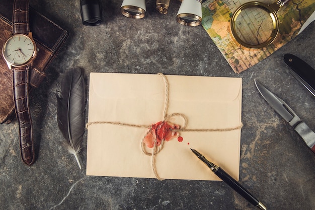 Travel items and vintage letter on grey marble table