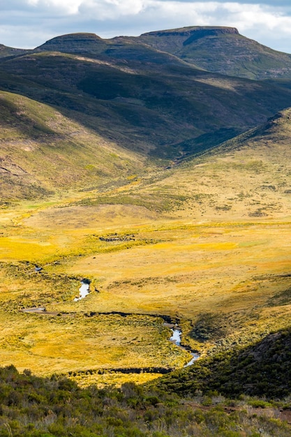 Travel to Lesotho A river meanders through a meadow in the mountains