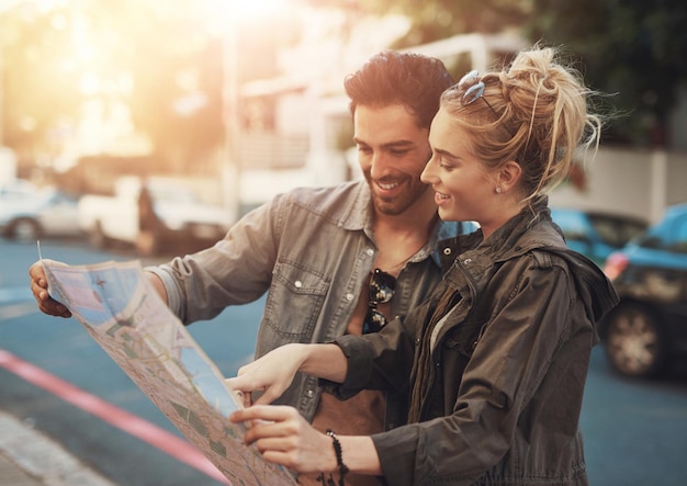 Photo travel man and woman in paper map smile and location search on urban holiday adventure in road walk guide and happy couple reading direction in city street for fun vacation in europe together