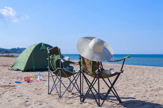 Travel to the sea. tent and camping chair on the beach.