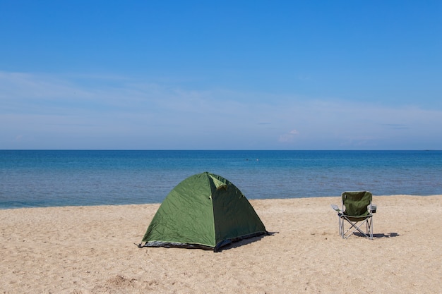 Travel to the sea. tent and camping chair on the beach.