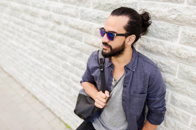 travel, tourism, lifestyle and people concept - man with backpack standing at city street wall