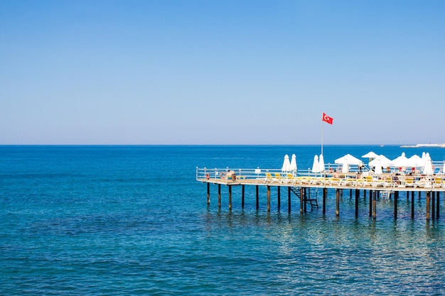 Travel and vacation background - wooden pier with chairs and umbrellas in Turkey