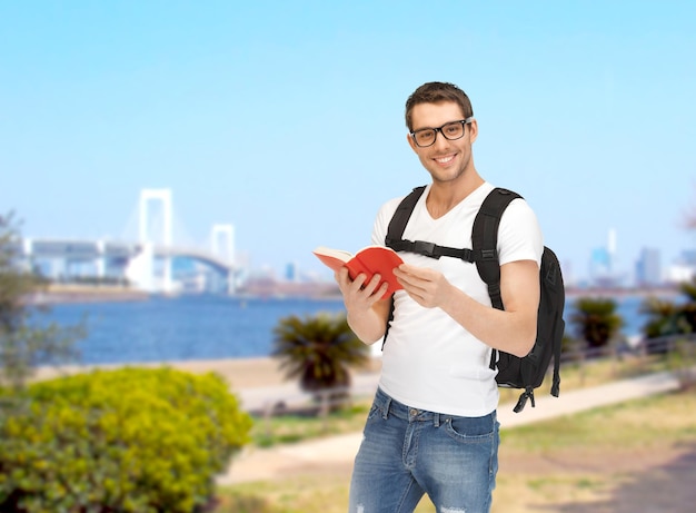 travel, vacation and education concept - travelling student with backpack and book