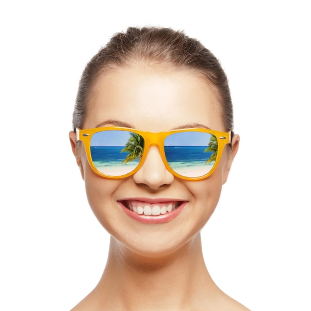 travel, vacation, summer holidays and happy people concept - portrait of happy teenage girl in sunglasses with beach reflection