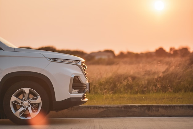 Travel white car parked on road sunset background