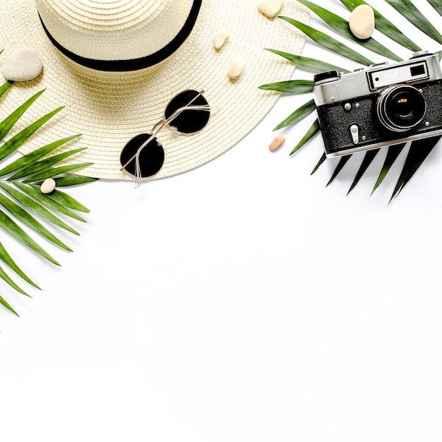 Traveler accessories tropical palm leaf branches on white background with empty space for text trave