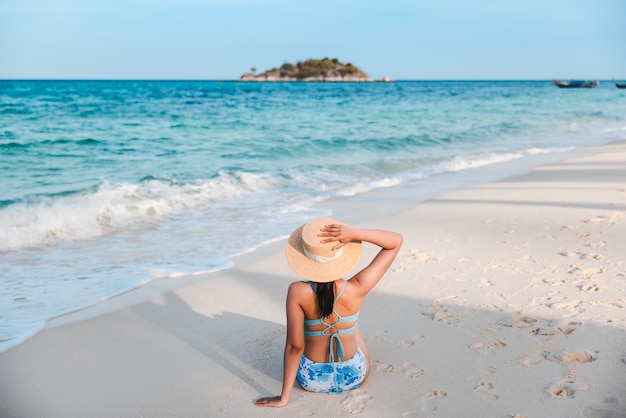 Traveler asian woman with bikini and hat relaxing on sea beach at day in Koh Lipe, Satun, Thailand