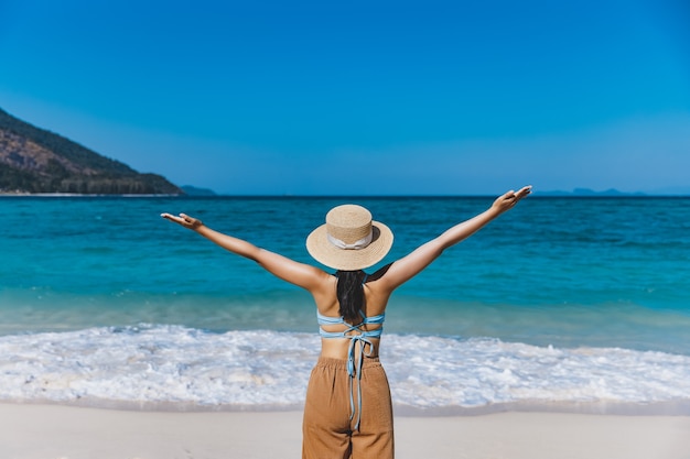 Traveler asian woman with bikini and hat relaxing on sea beach at day in Koh Lipe, Satun, Thailand