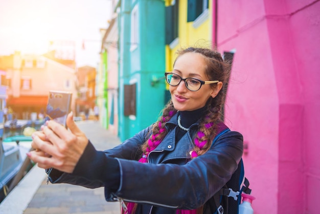 Traveler blogger taking selfie photo near colorful houses on burano island in venetian lagoon travel