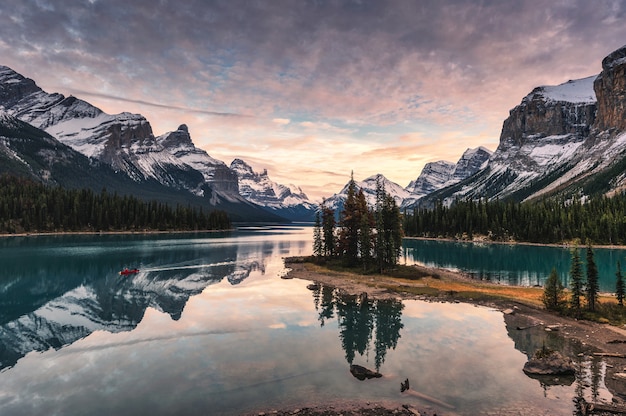 Traveler canoeing with rocky mountain reflection on Maligne lake at Spirit island in Jasper national park, Canada