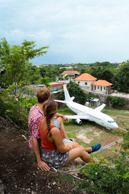 Traveler couple dreaming of traveling again while they see an abandoned plane