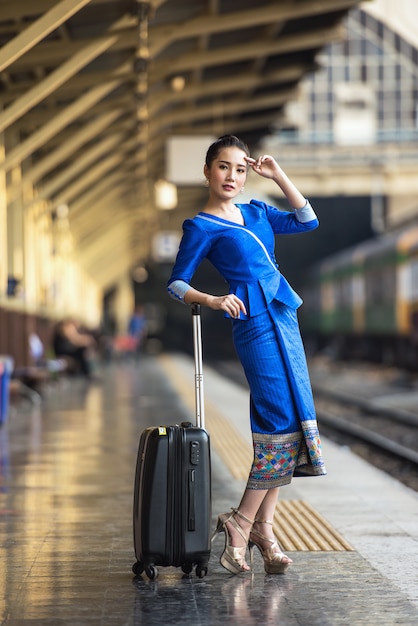 Traveler girl walking and waits train on railway platform